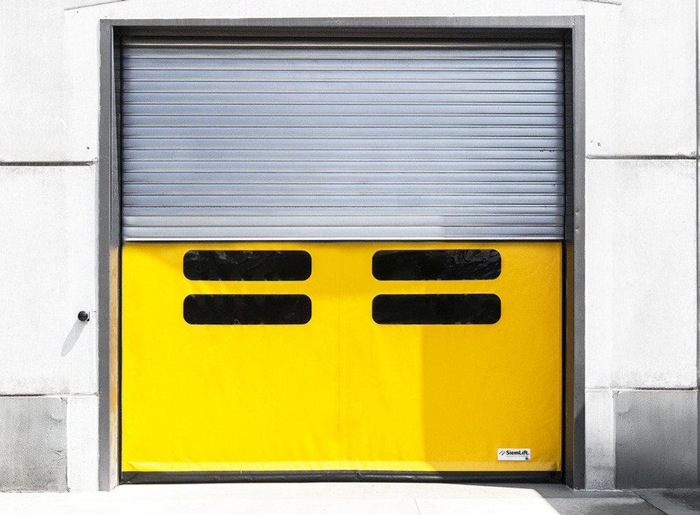 Porta combinata industriale con integrazione pedonale e accesso veicolare.