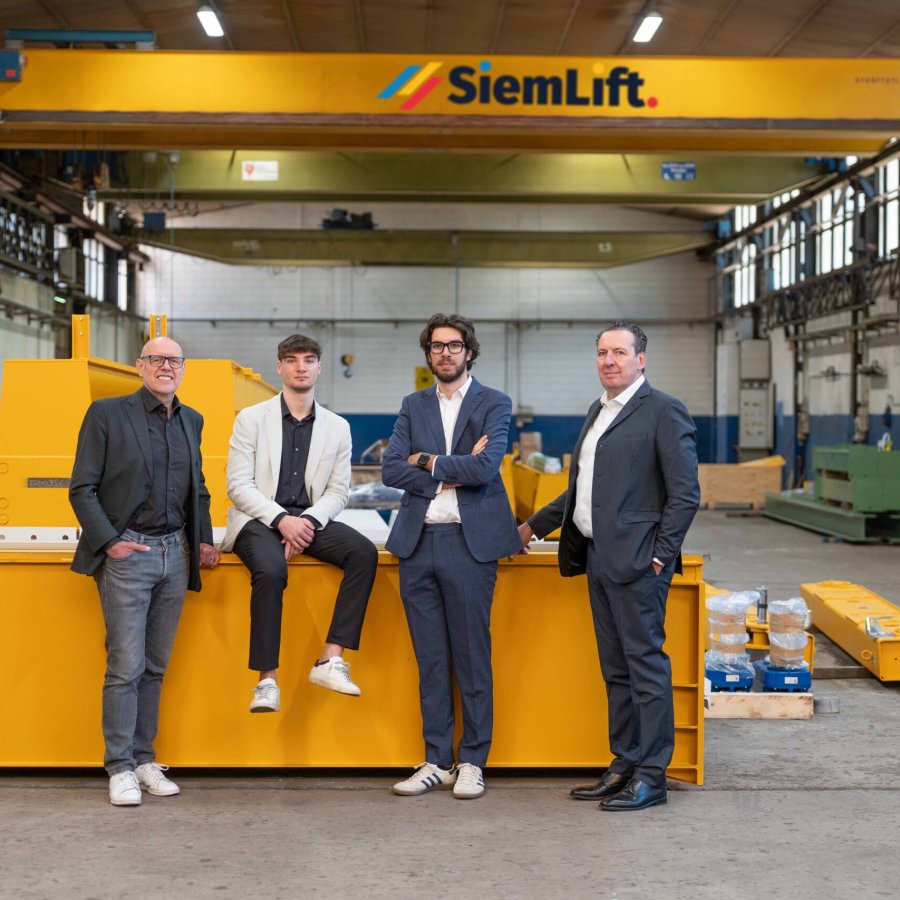 Team Siem Lift in officina con impianti di sollevamento industriale.